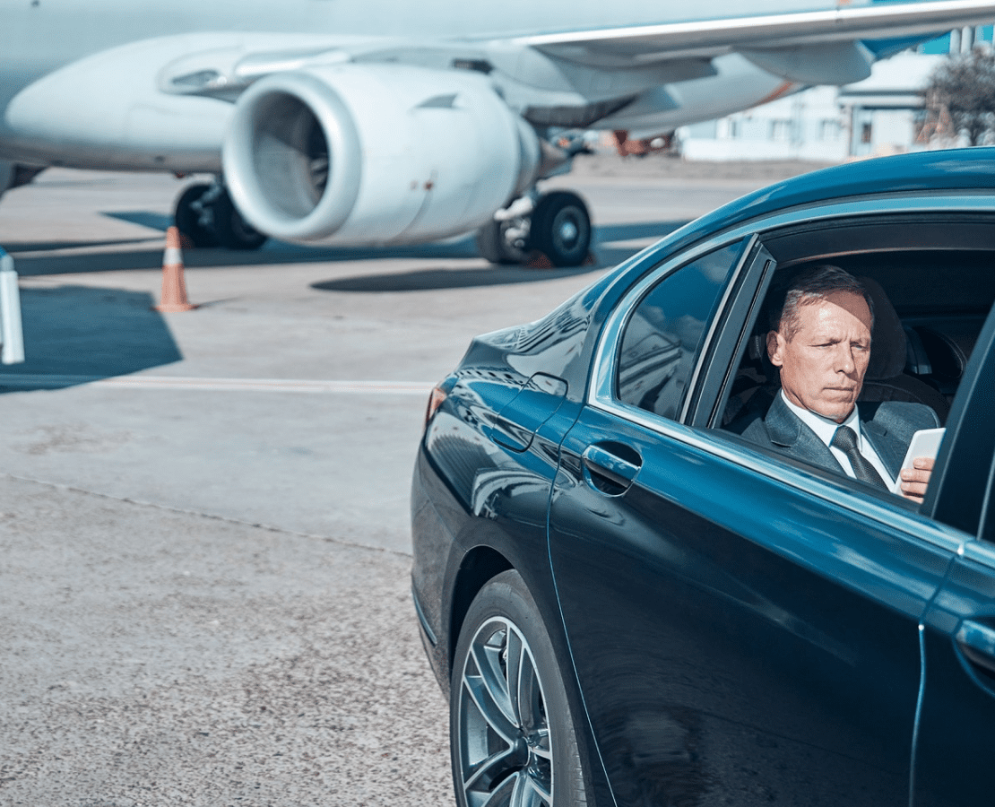 Executive businessman in luxury black car on airport tarmac - LuxRide airport transfer service Tampa Bay Florida