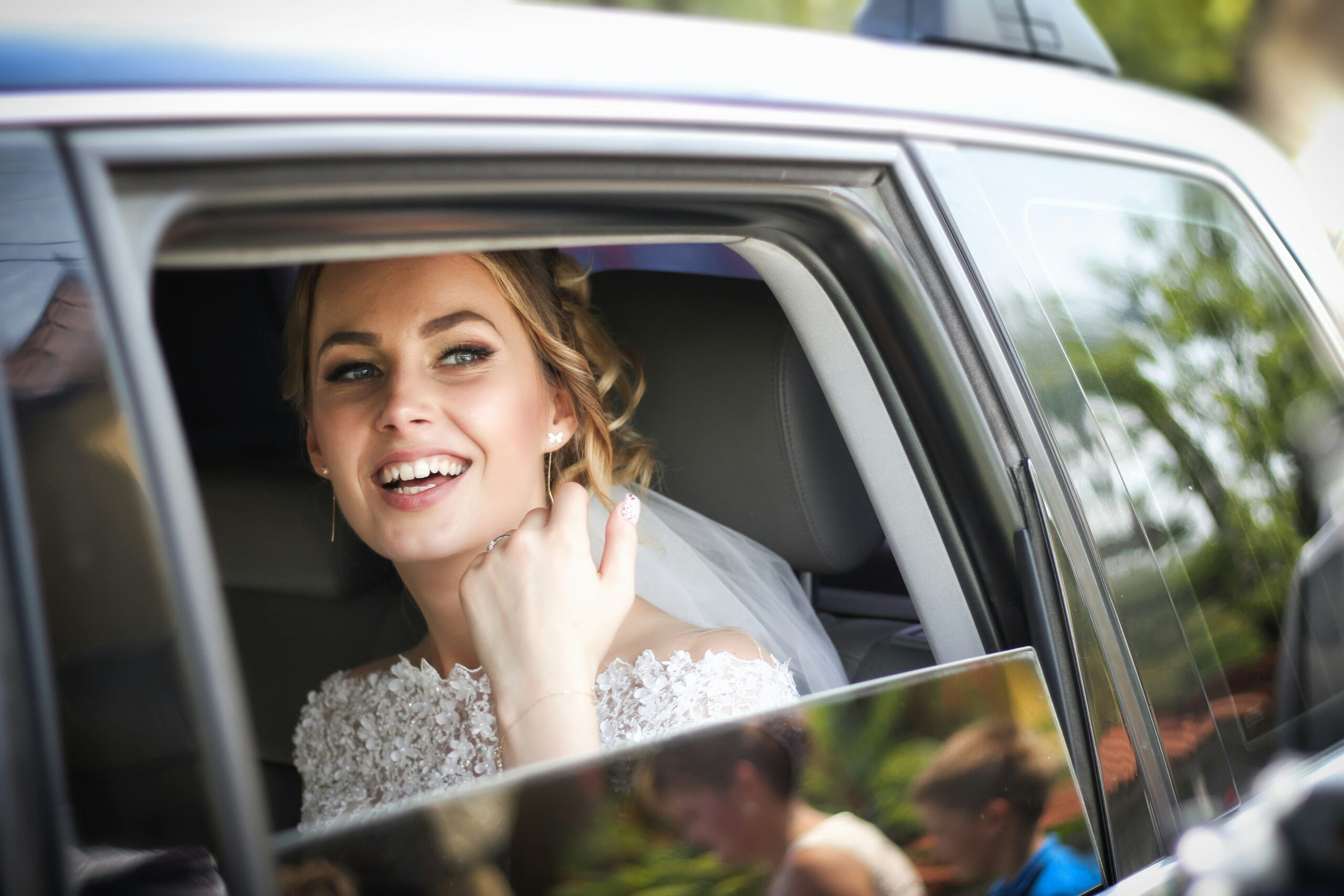 Happy bride in wedding dress in luxury car - LuxRide special events wedding transportation Tampa Bay Florida