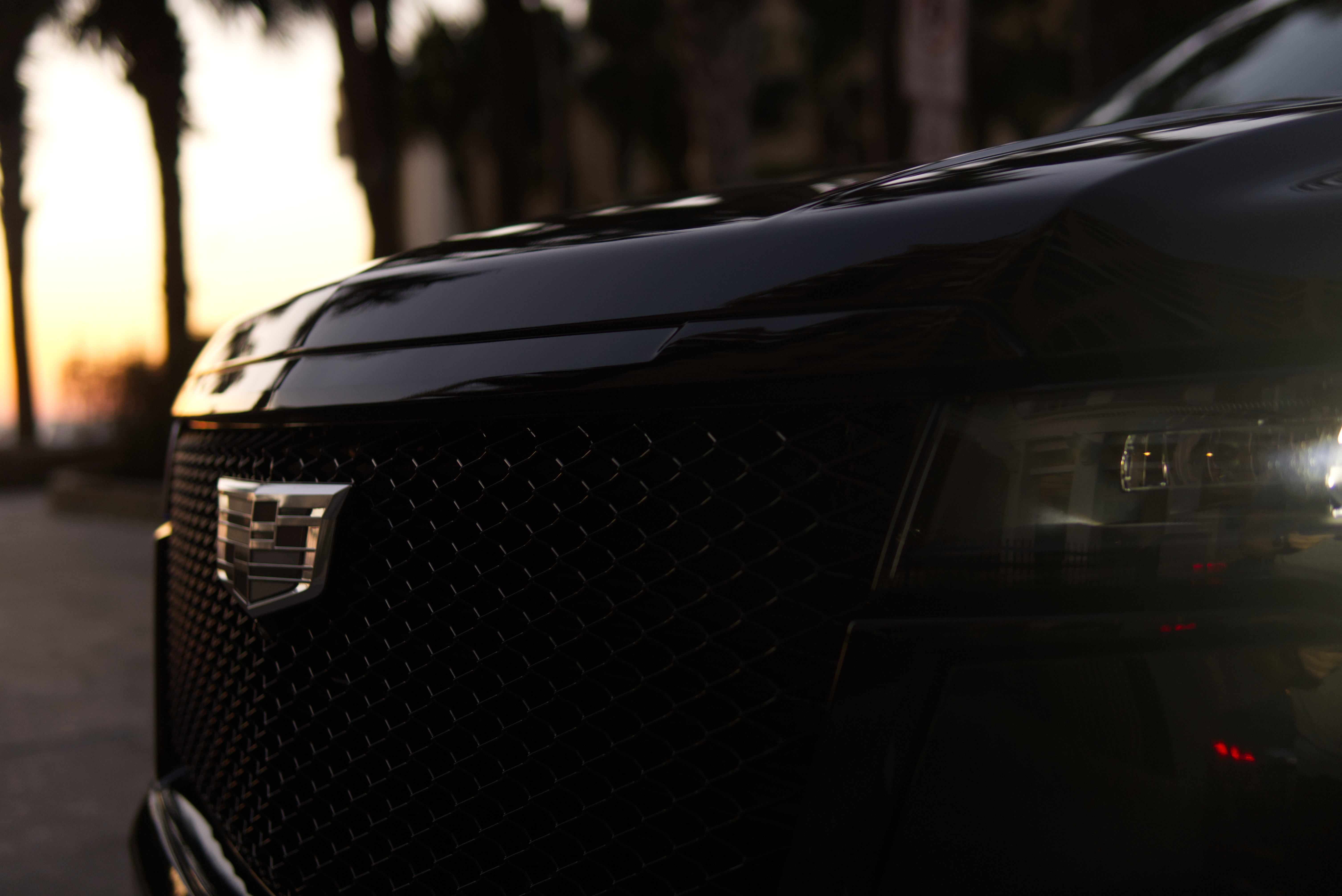 Cadillac Escalade grille close-up at sunset - LuxRide premium fleet