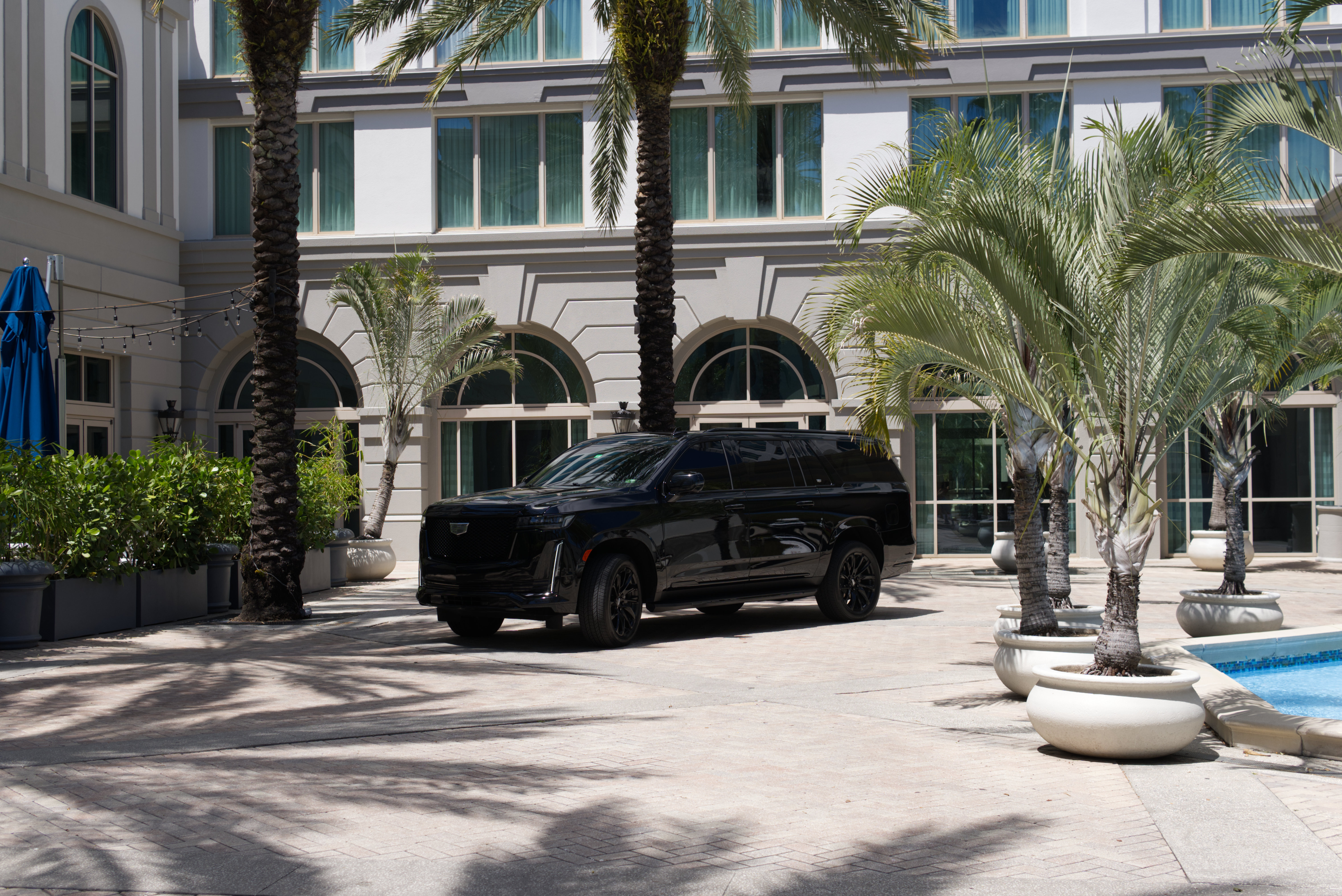Black Cadillac Escalade at luxury hotel courtyard - LuxRide Florida transportation
