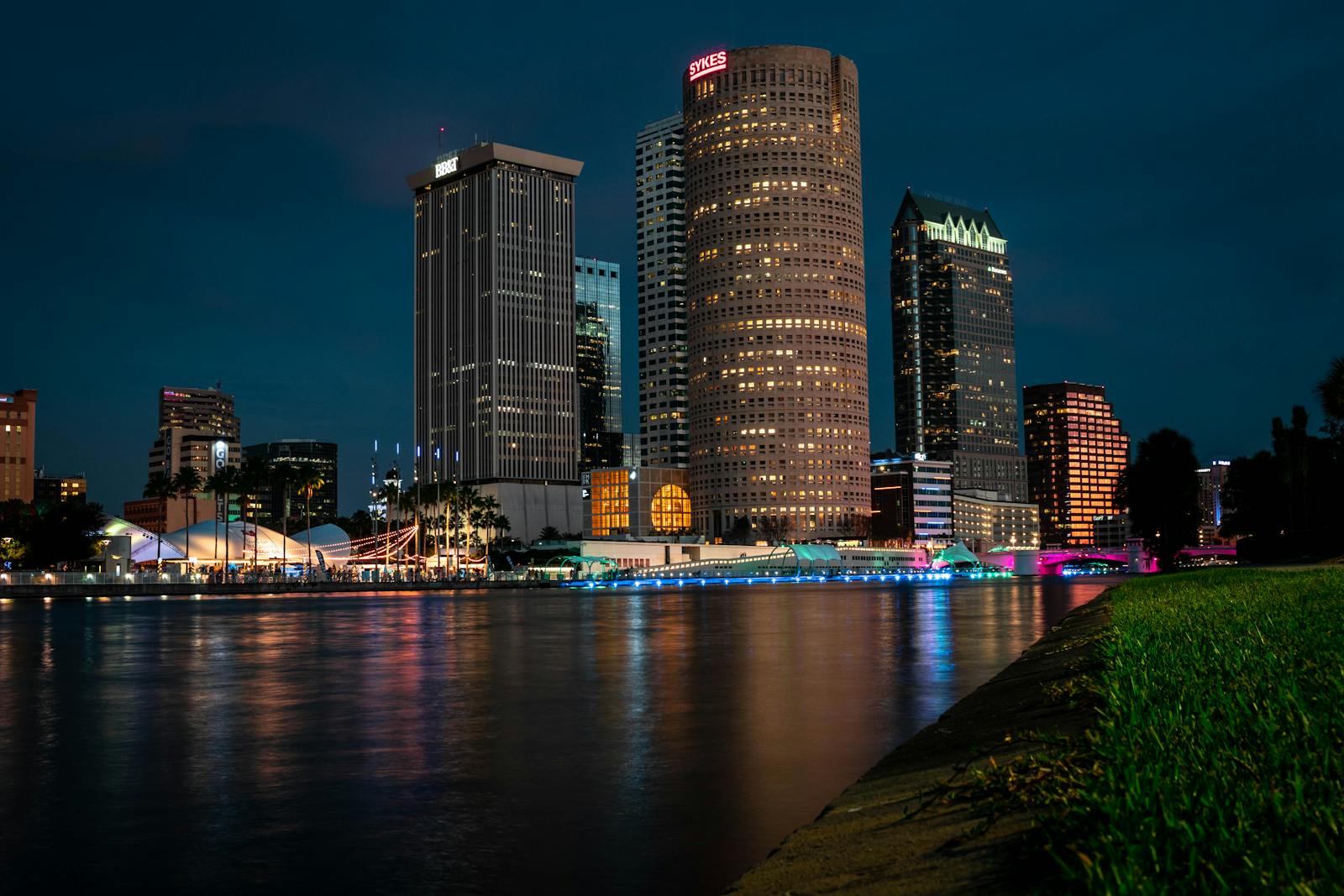 Downtown Tampa Bay corporate skyline illuminated at night over the Hillsborough River